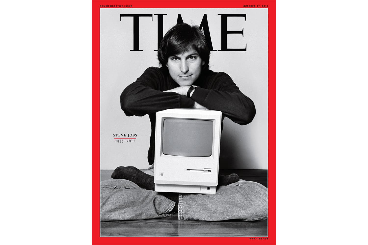 Steve Jobs seated cross-legged with an early Macintosh computer, on a magazine commemorative cover