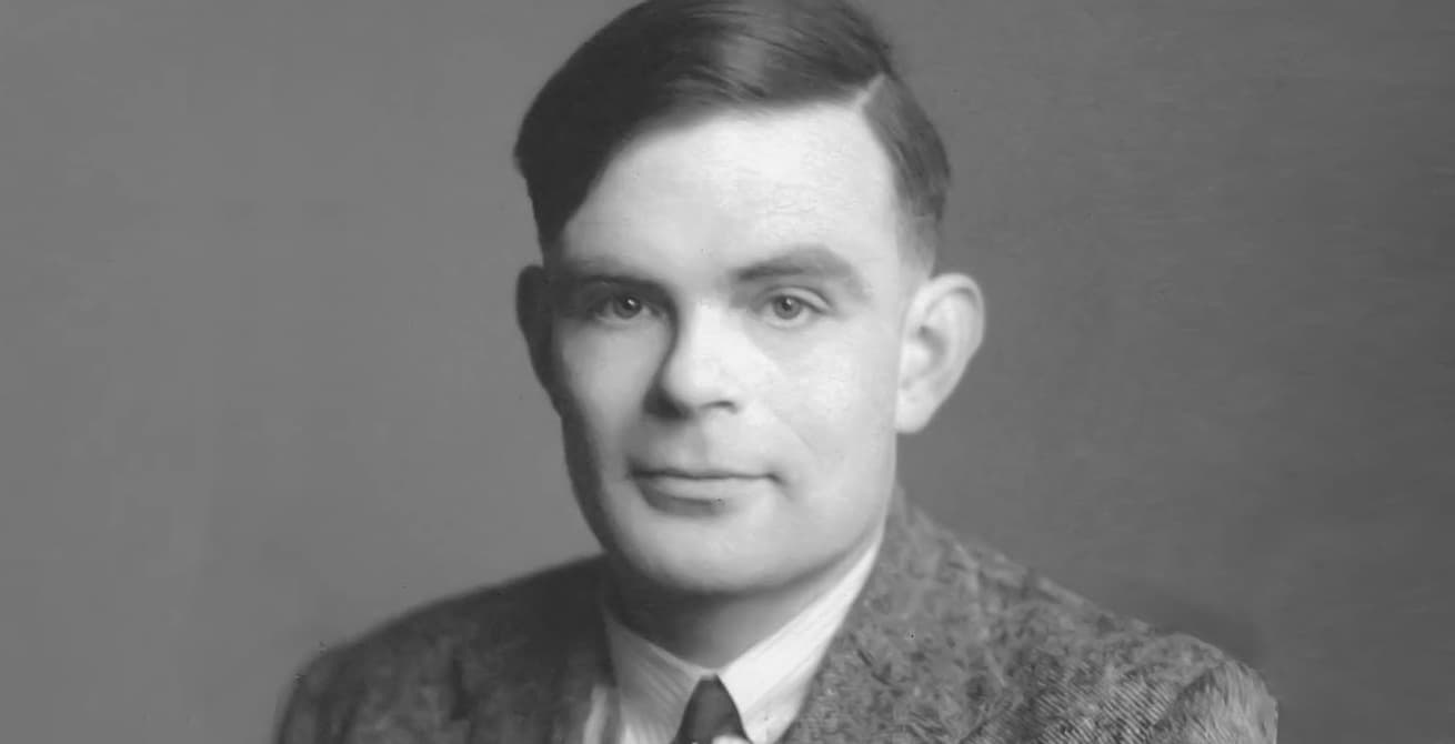 Black-and-white portrait of Alan Turing as a young man in a tweed jacket