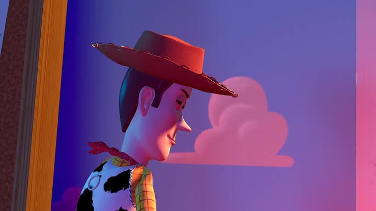 Woody in profile, looking pensive against a dusk-lit window